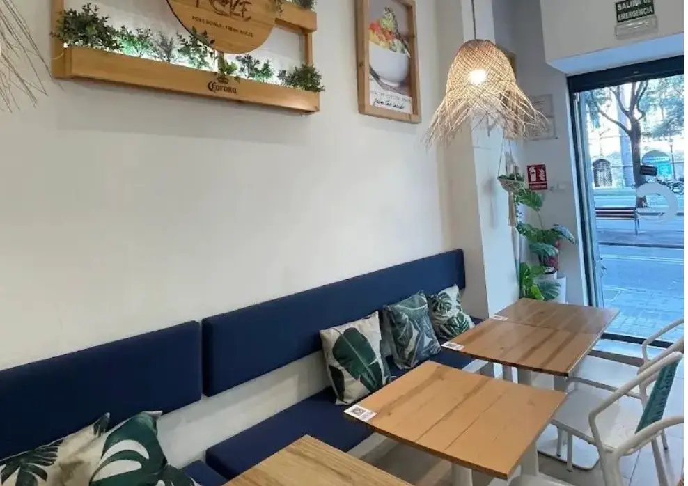 Zona de mesas junto a la puerta de entrada acristalada en cafetería brunch con licencia C2 en traspaso en la Diagonal, Barcelona.